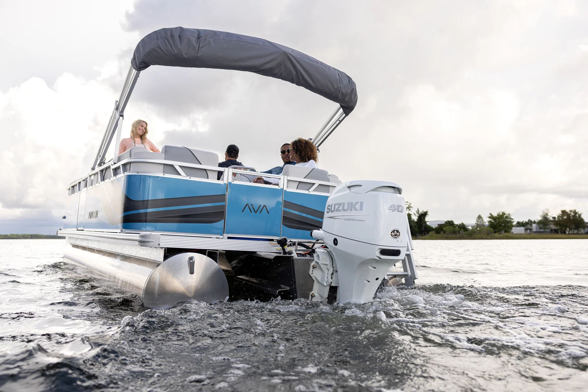 People enjoy a sunny day on a blue and white pontoon boat with an outboard motor.