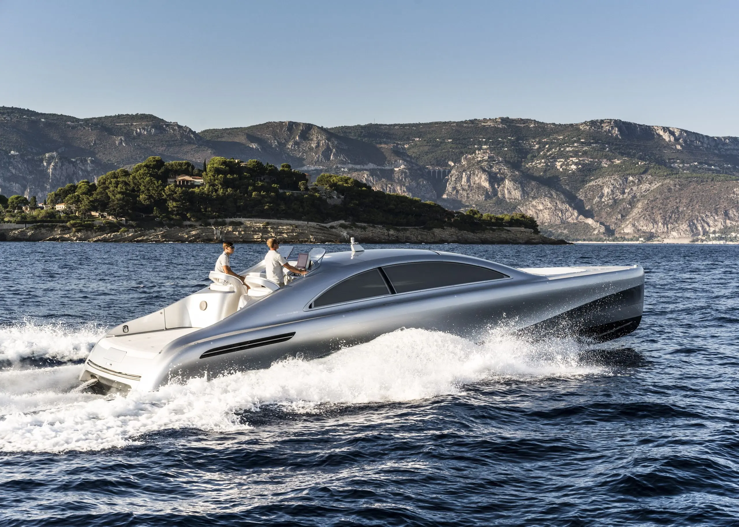 A YANMAR-powered Silver Arrows sport yacht running at speed along a rocky coastline