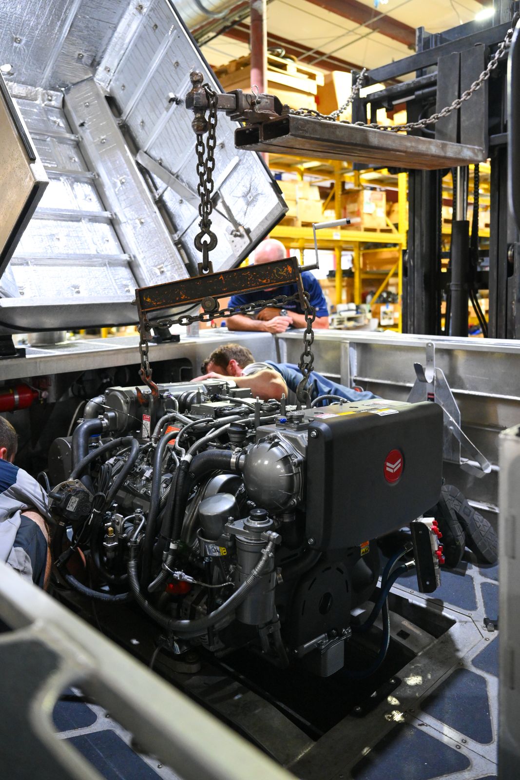 A YANMAR marine diesel being lowered into a boat in the Mastry shop